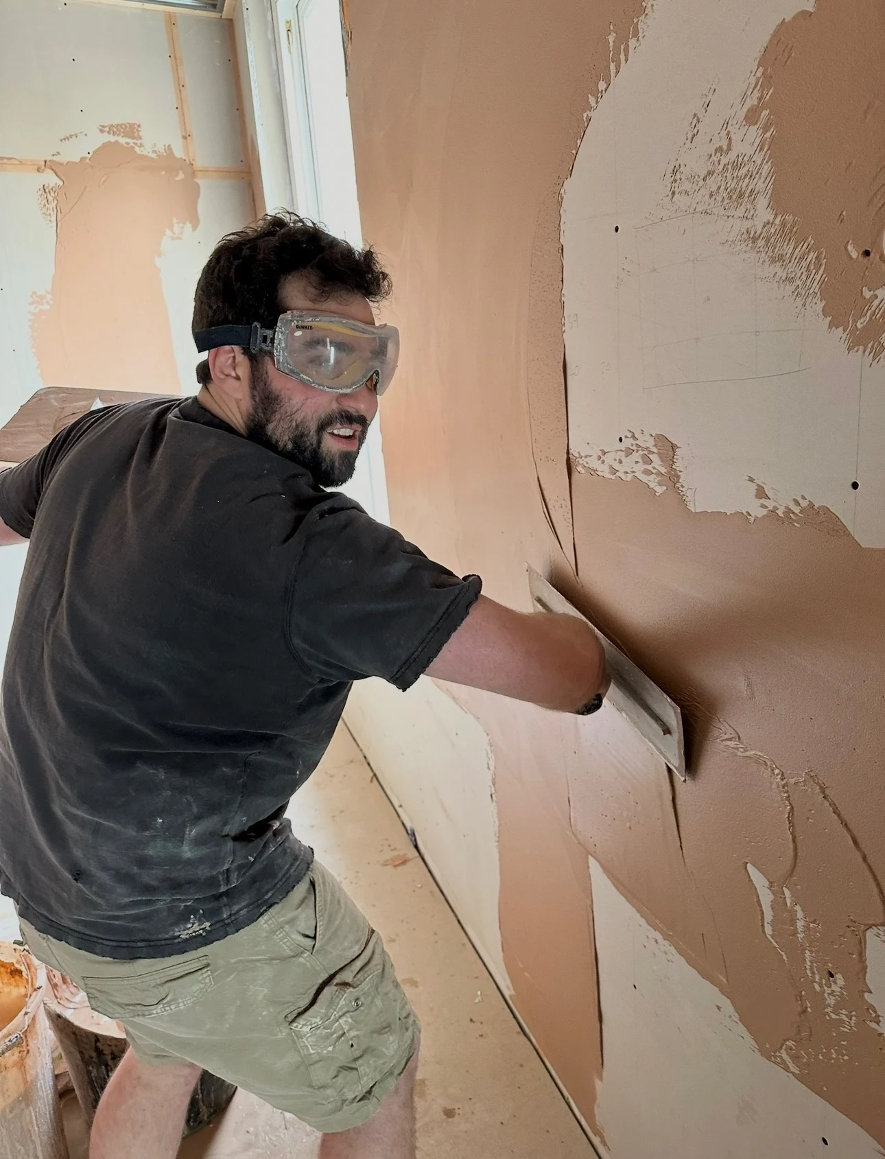 Community Heroes volunteer plastering a wall during multi-trade property maintenance